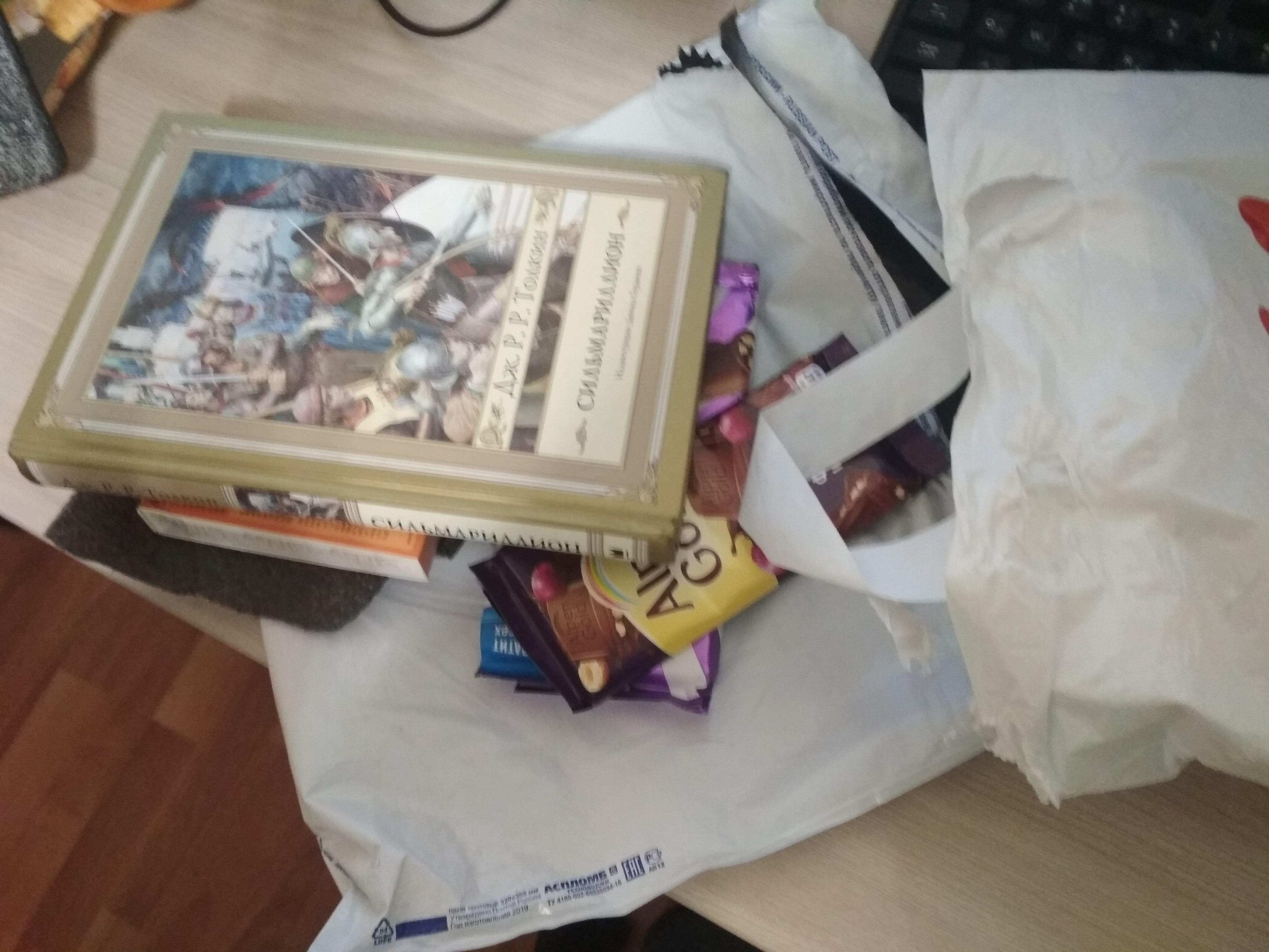 Из упаковки выпала книга и столько шоколада что у меня заныли зубы.